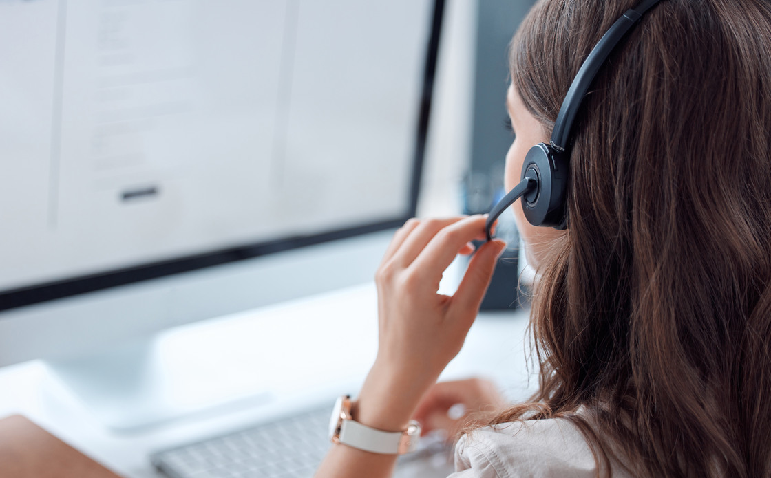 Customer support, call center and back of female agent working on online consultation in the office. Telemarketing, communication and saleswoman planning crm with headset and computer in workplace