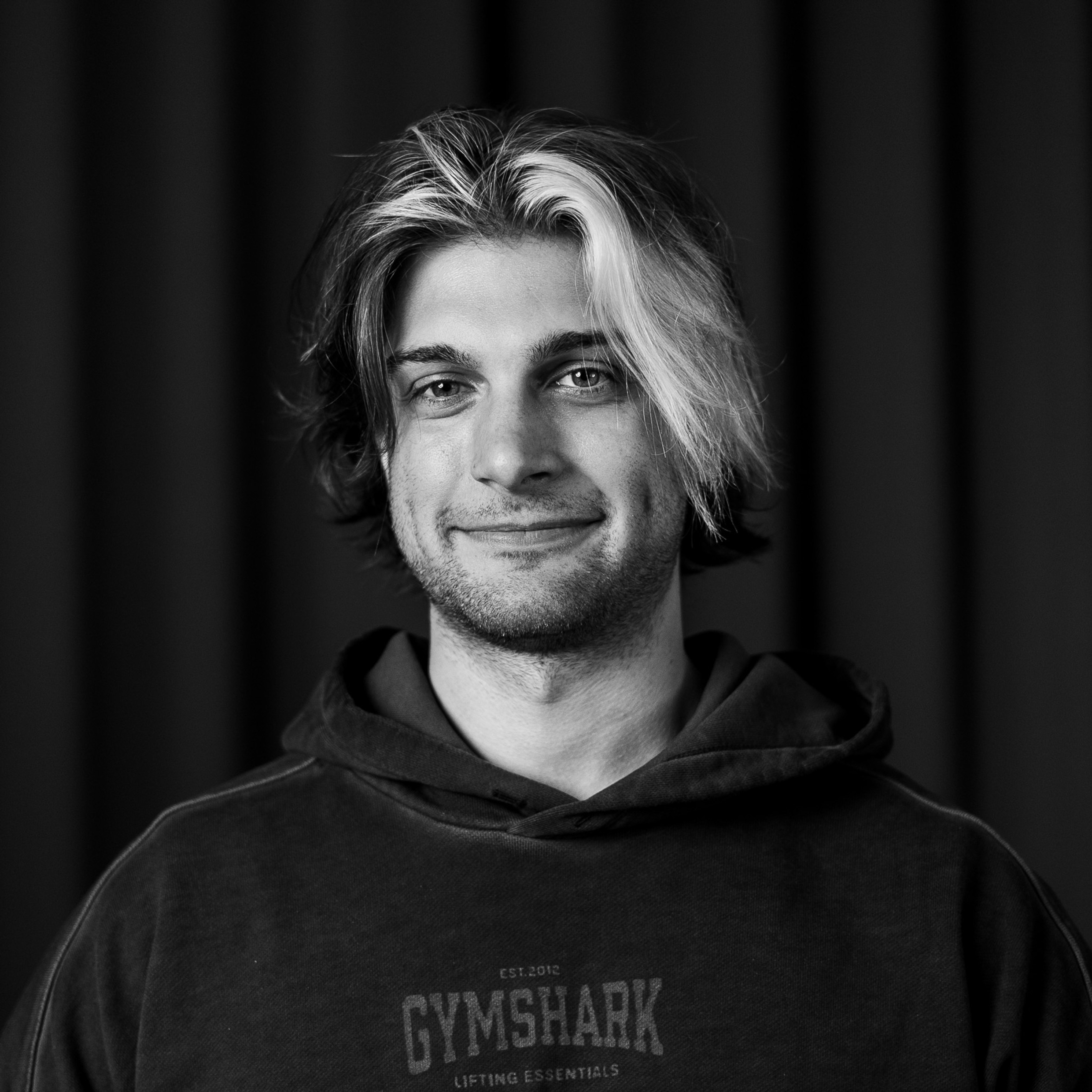 Ett svartvitt foto av en man i huvtröja.