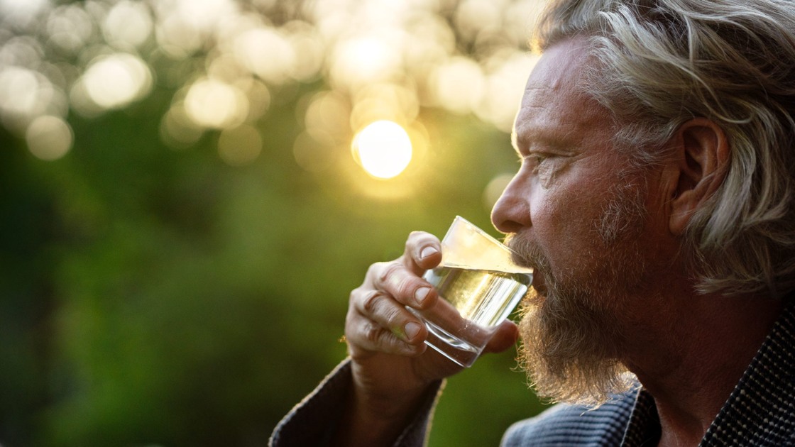 En man som dricker vatten ur ett glas.