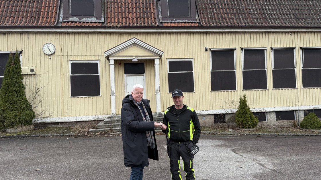 Rolf Eriksson, ordförande i samhällsbyggnadsnämnden i Tibro kommun, lämnar över nycklarna till Gamla Smulebergsskolan till fastighetens nya ägare Jörgen Larsson på Storängens fastigheter i Skövde.