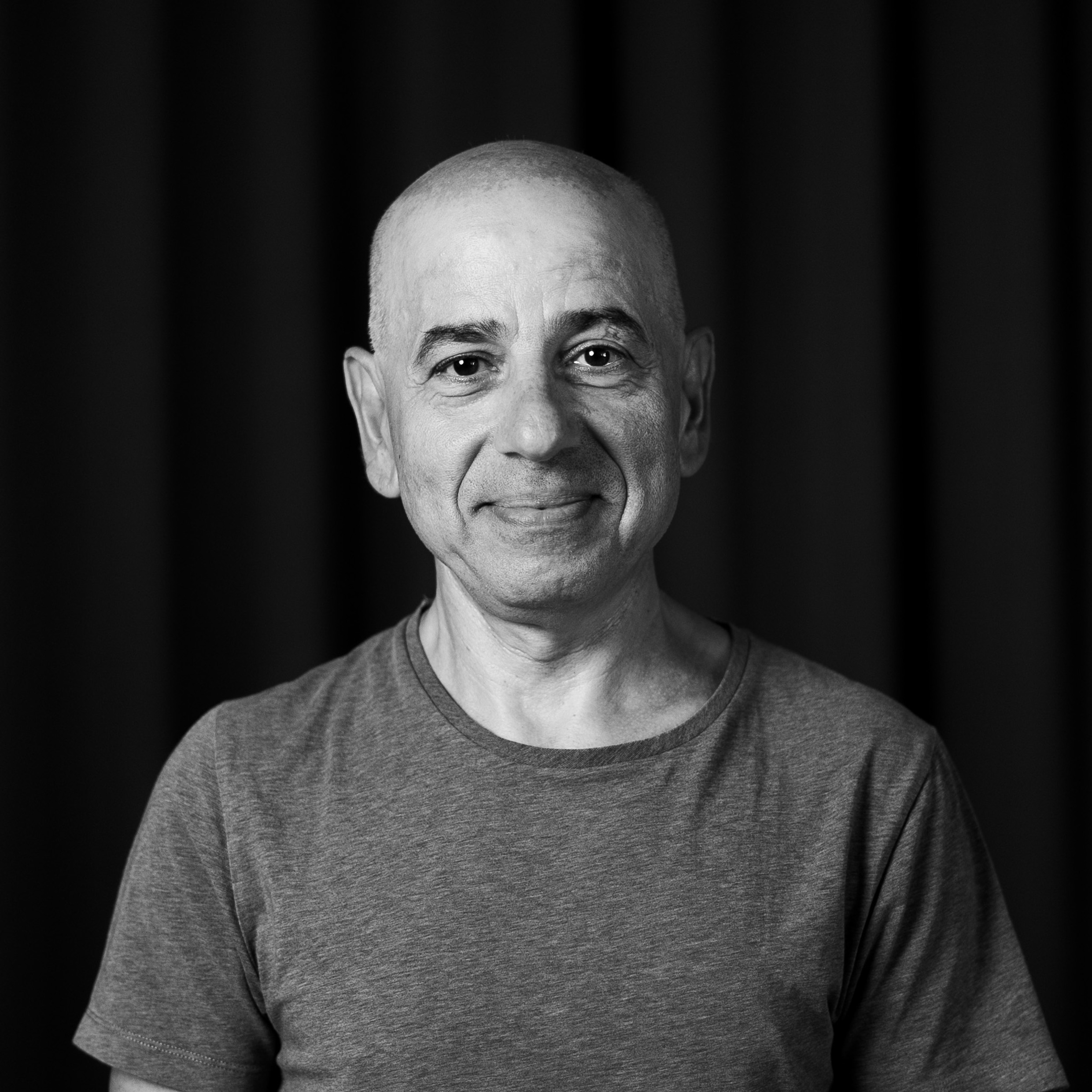 Ett svartvitt foto av en man som ler.