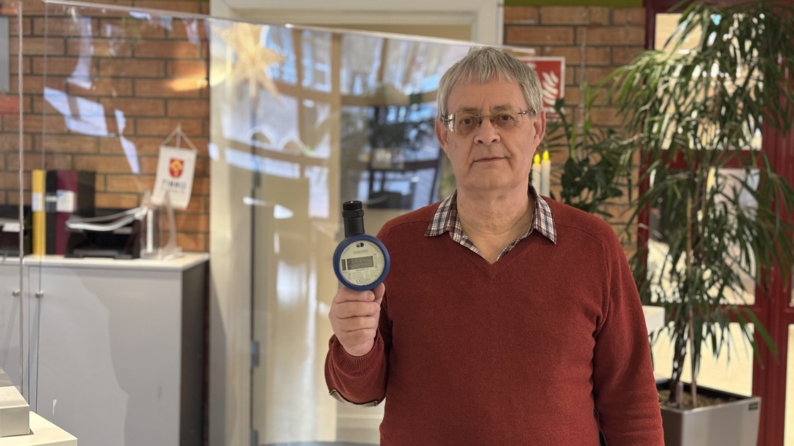 VA-chef Mikael Jonsson håller upp vattenmätare i receptionen Tibro kommun