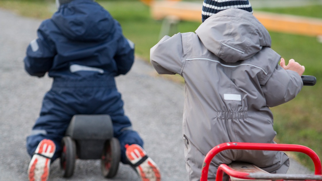 Barn som cyklar på en grusväg