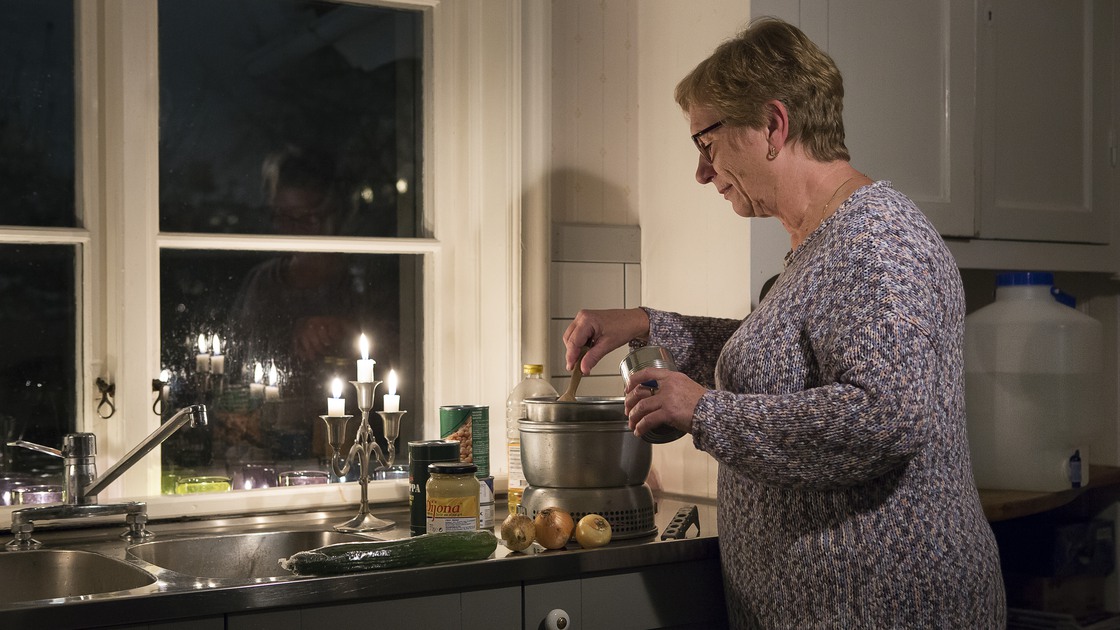 Kvinna som lagar mat på stormkök.