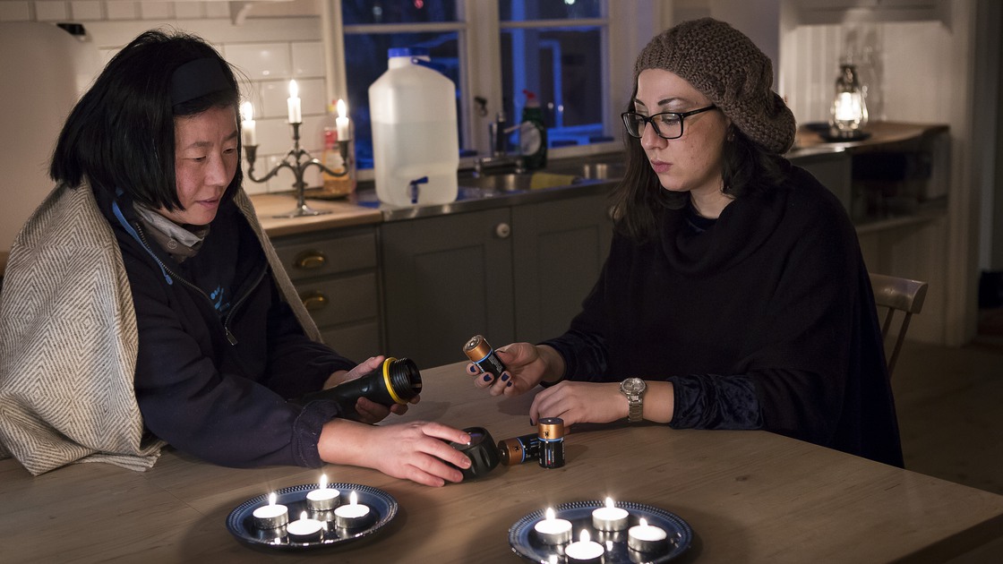 Familj som sitter vid ett köksbord under ett strömavbrott.