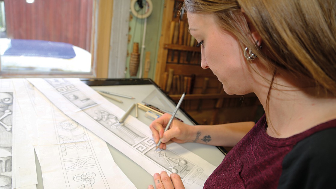 Bildhuggaren Emilia Lehrgrafven gör skisser på bildhuggerihandtagen till Baggeboskolans dörrhandtag.