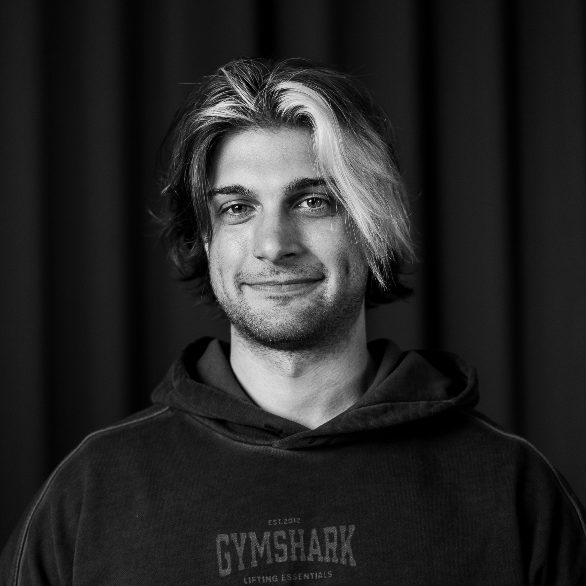 Ett svartvitt foto av en man i huvtröja.