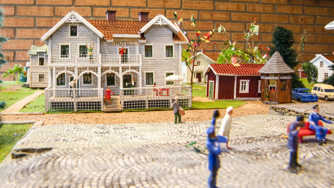 Hus i beige färg med gran vid sidan