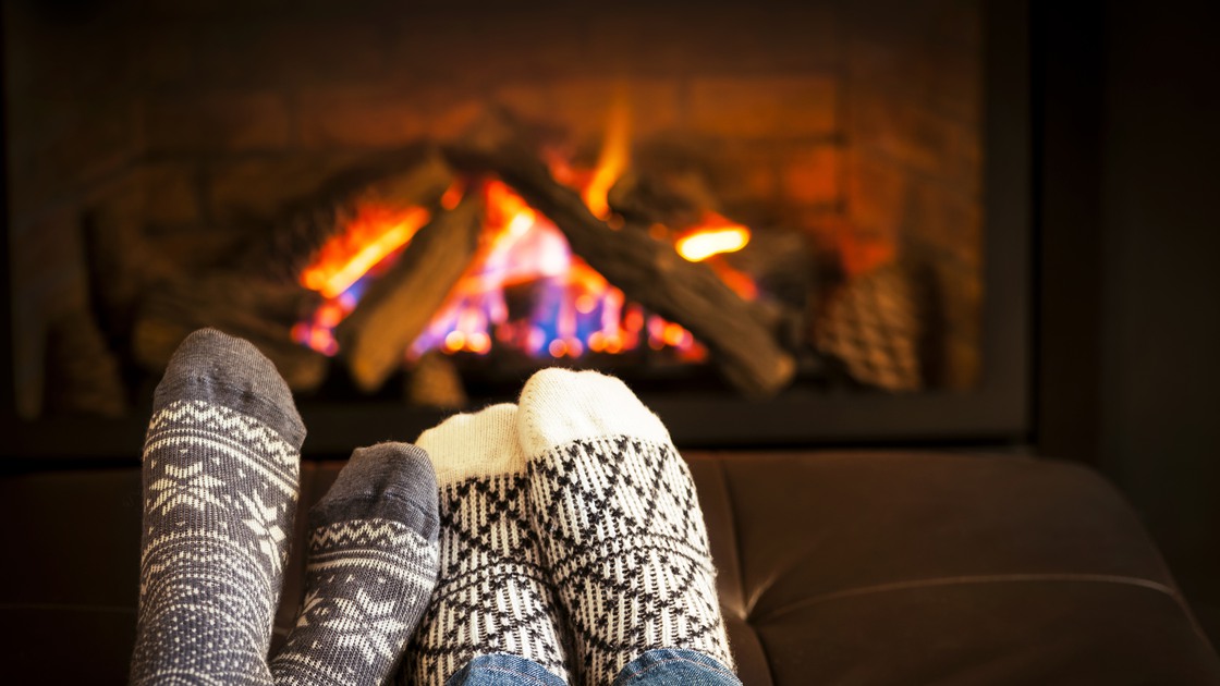 Fötter som värms framför en bras.