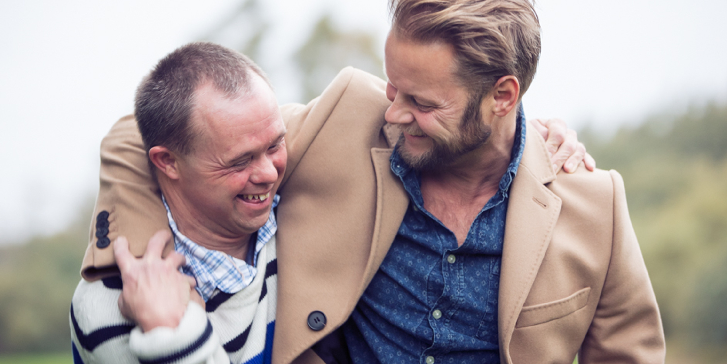 Två män som kramar varandra.