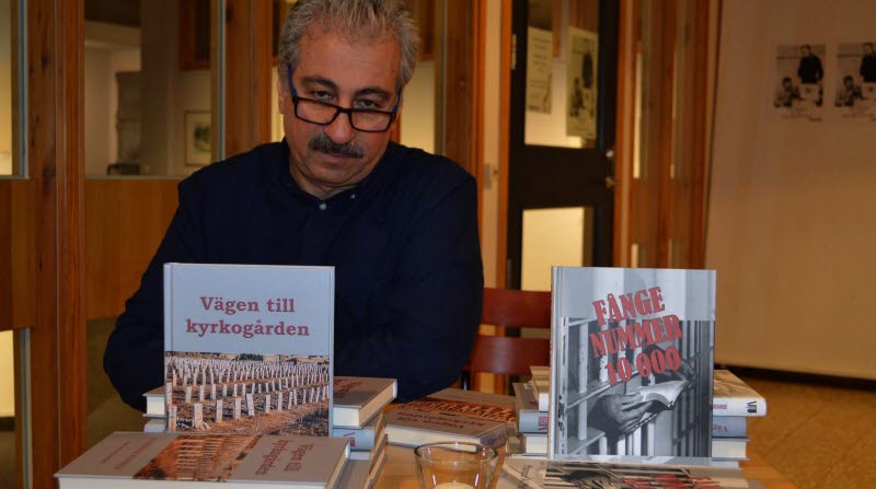 Författaren Mansour Al-Mansour visar upp två av sina böcker.